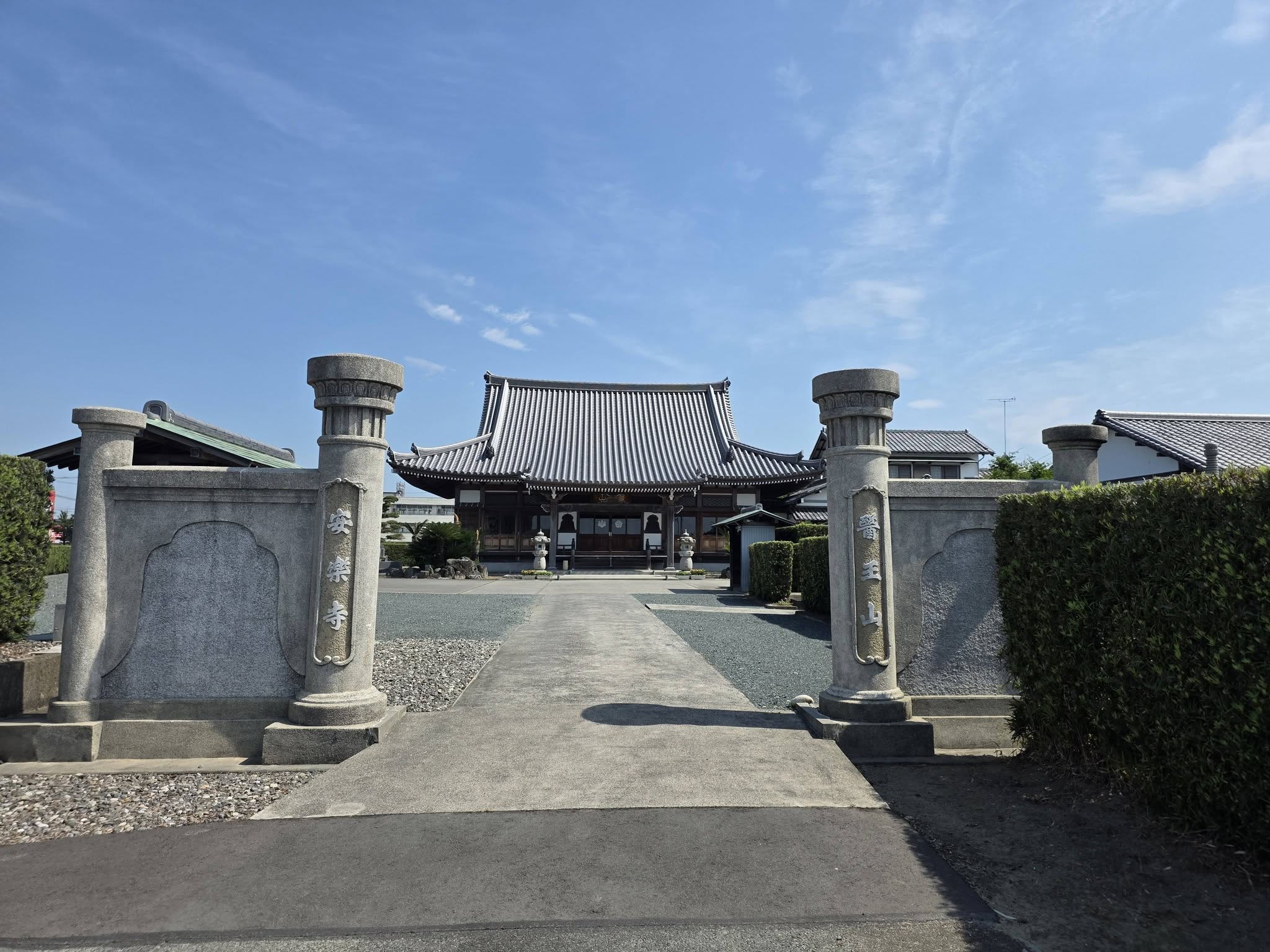 安楽寺と医王山の寺号を刻む門柱と本堂