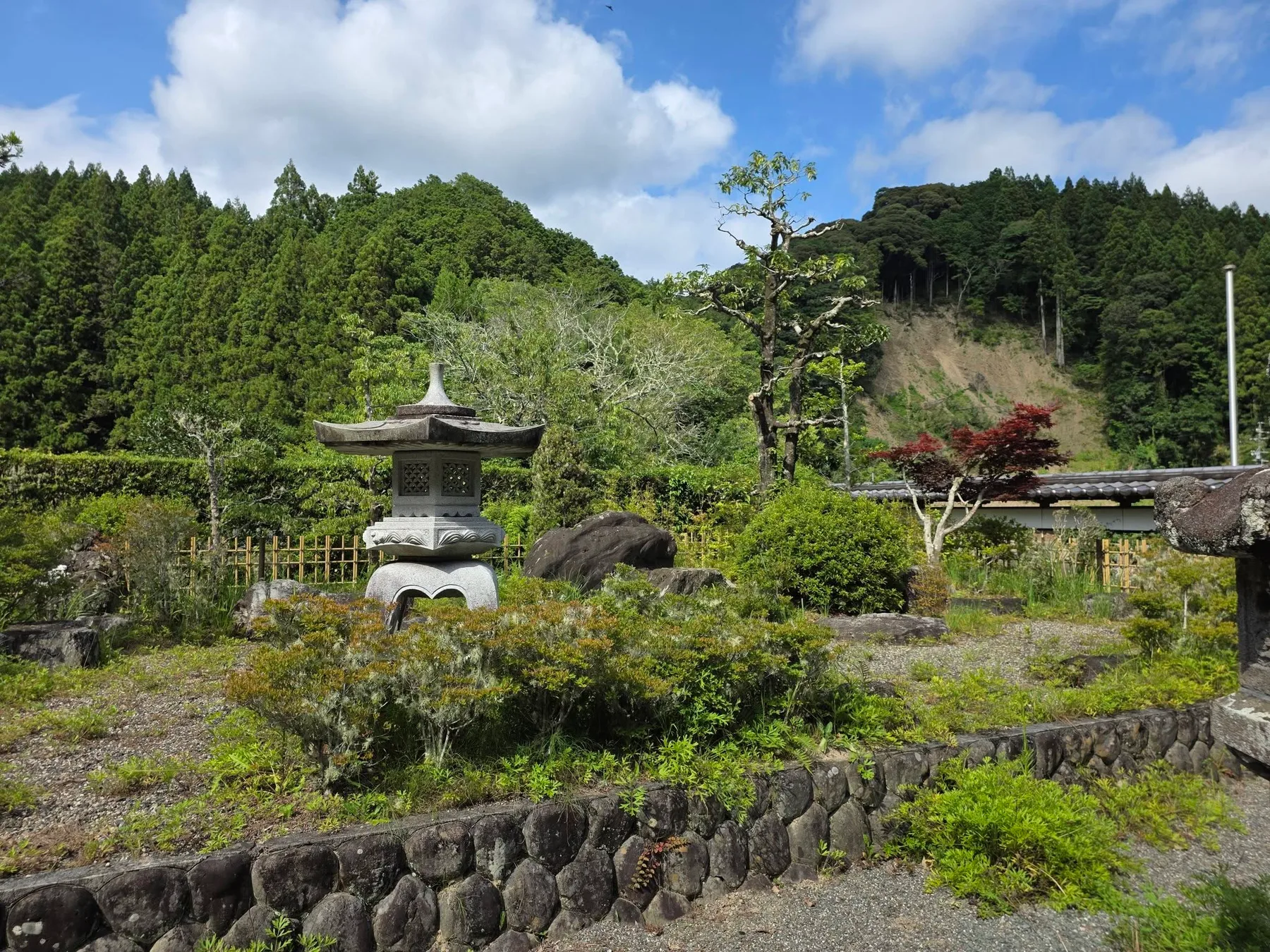 一雲斉境内の石灯籠と背後の山林
