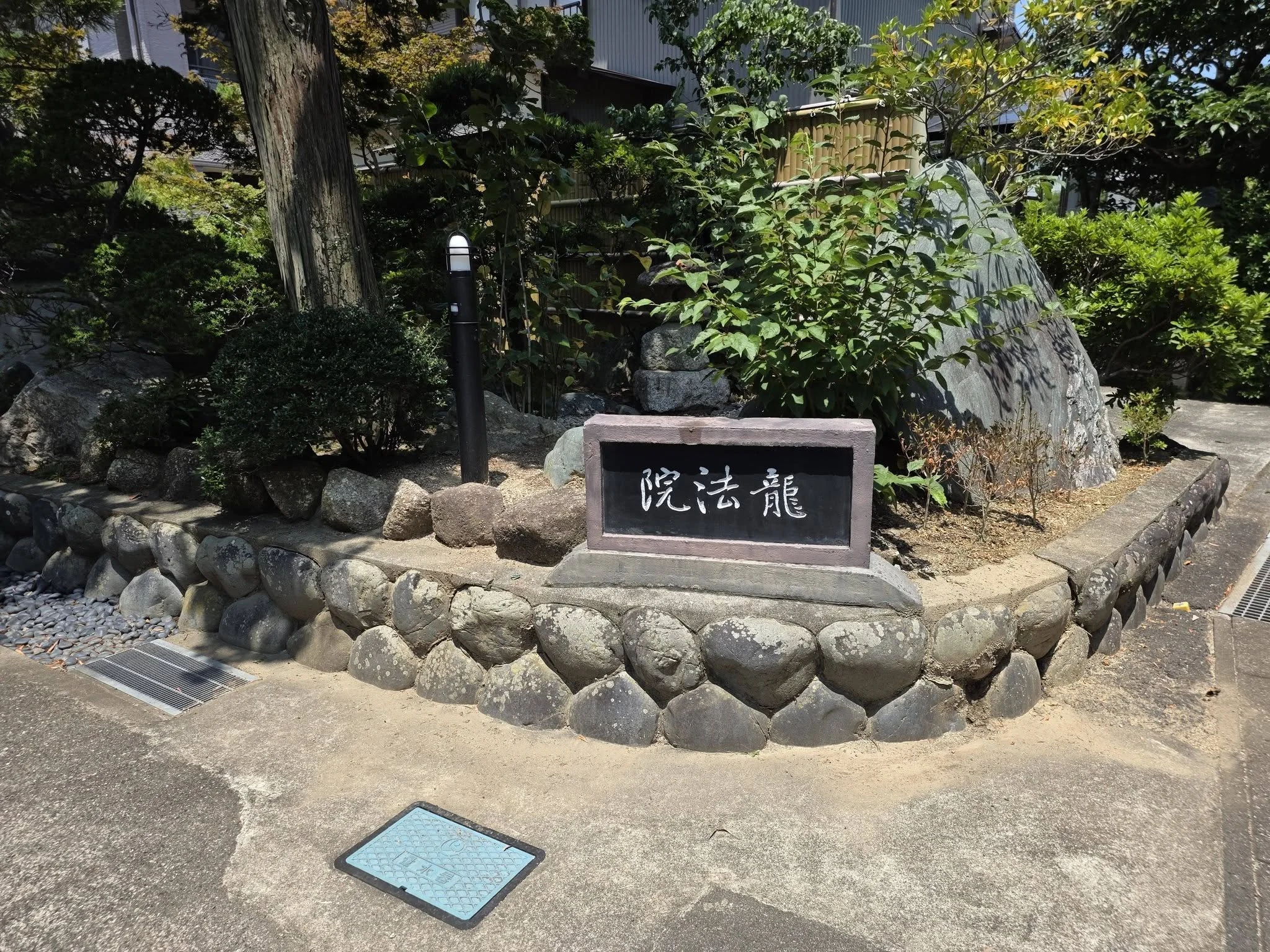 龍法院の寺名板と石造物