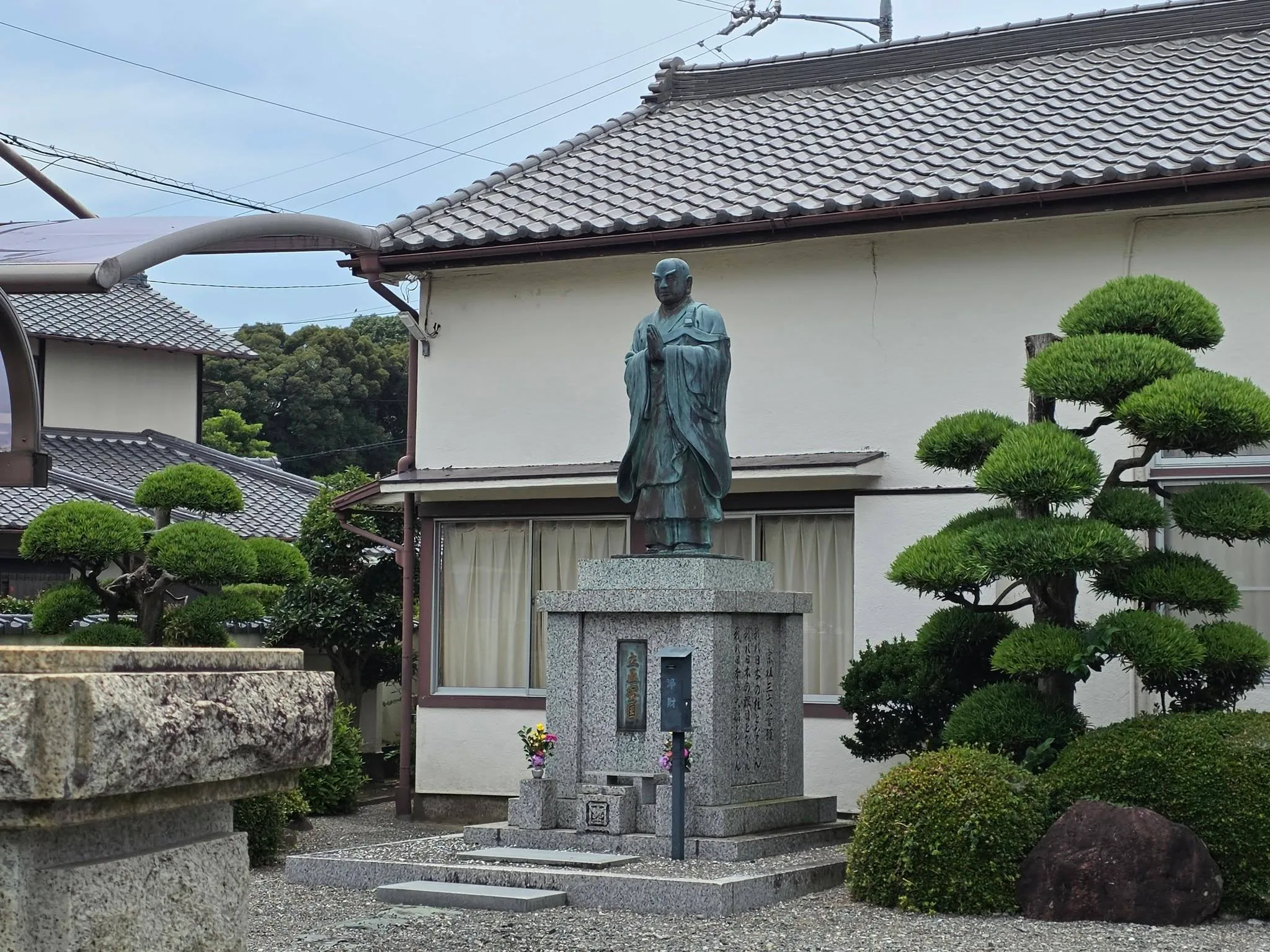 立正安国銘を伴う合掌姿の僧形銅像